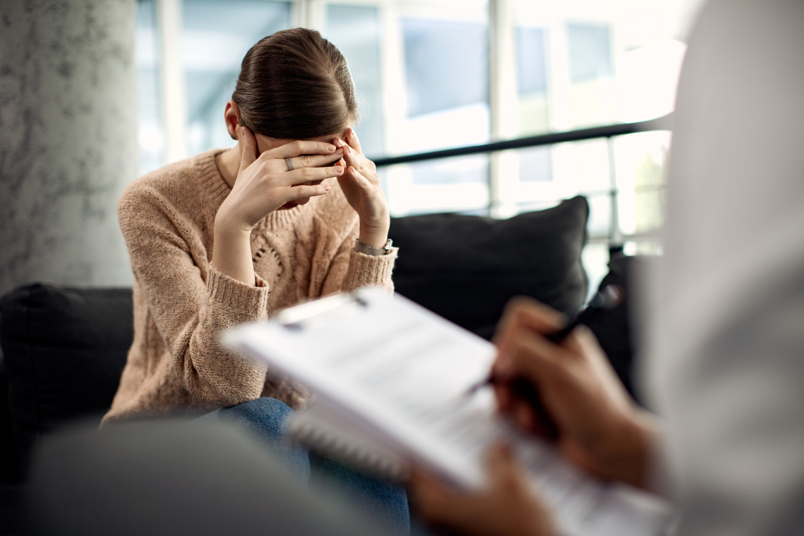 Depressed woman having psychotherapy session at doctor's office.